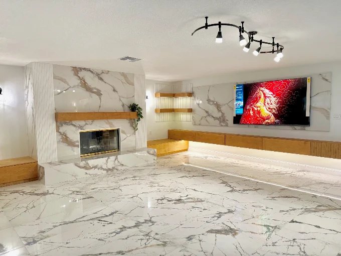 Full-height marble fireplace and media wall with a floating bench seat and open display niches.